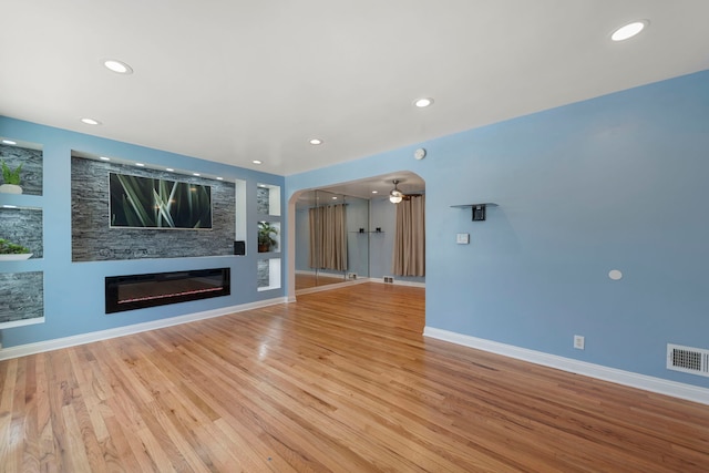 unfurnished living room featuring ceiling fan and light hardwood / wood-style flooring