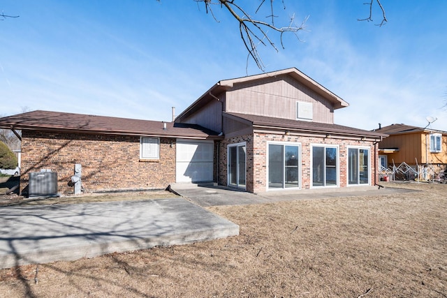 back of property featuring a garage, a patio, a yard, and central AC