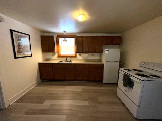 kitchen with sink, white appliances, and light wood-type flooring