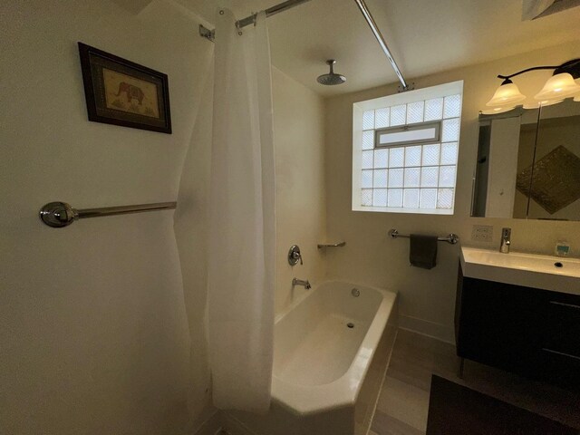 bathroom featuring vanity and shower / bathtub combination with curtain