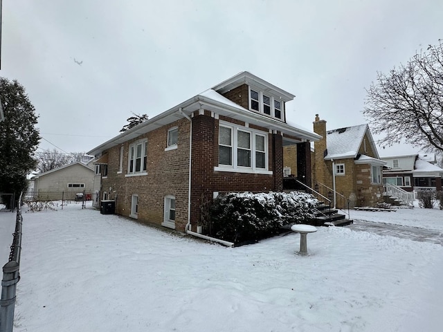 view of snow covered exterior featuring cooling unit