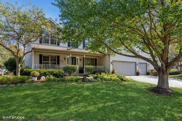 view of front of home with a garage, a front yard, and covered porch