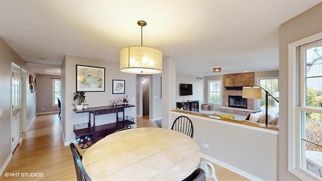 dining space featuring a fireplace and light hardwood / wood-style flooring