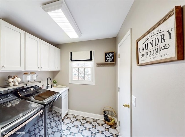 clothes washing area featuring cabinets, sink, and washer and dryer