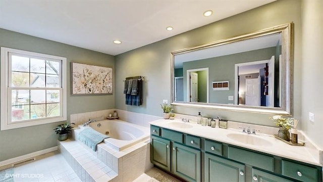 bathroom featuring vanity, tile patterned flooring, and tiled tub