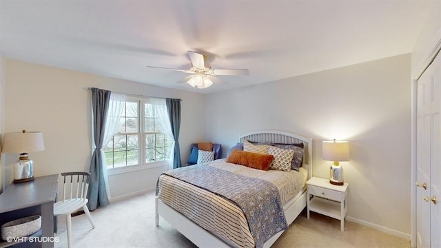 bedroom featuring light colored carpet, ceiling fan, and a closet