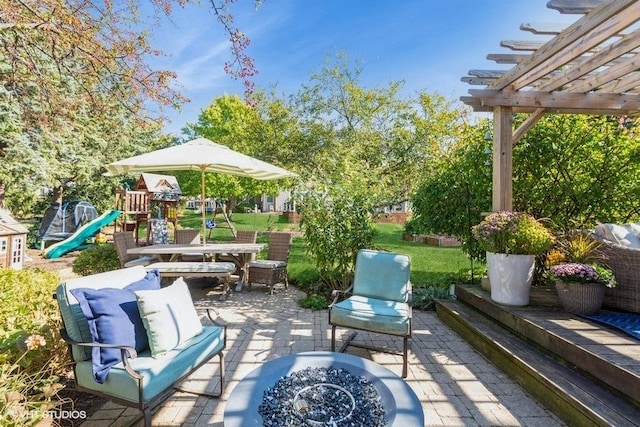 view of patio with an outdoor fire pit and a playground