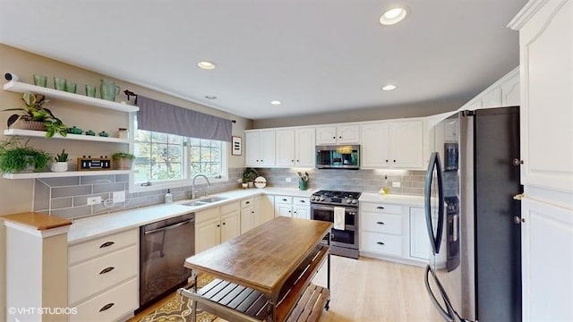 kitchen featuring tasteful backsplash, sink, stainless steel appliances, and white cabinets