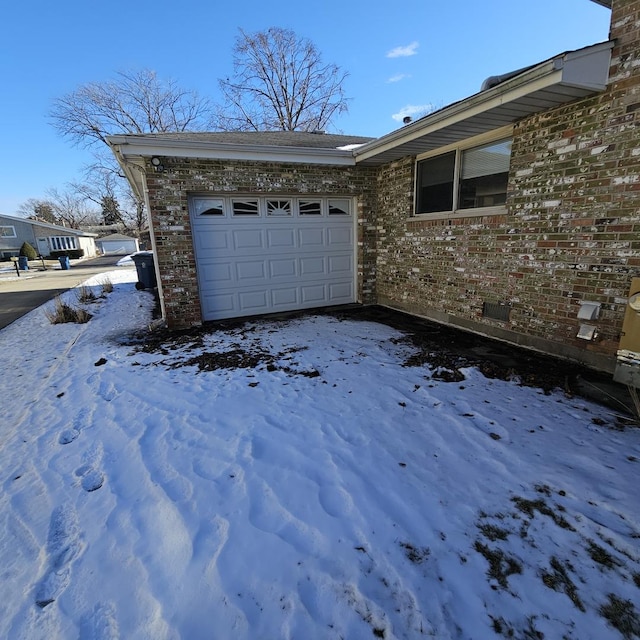 view of snowy exterior with a garage