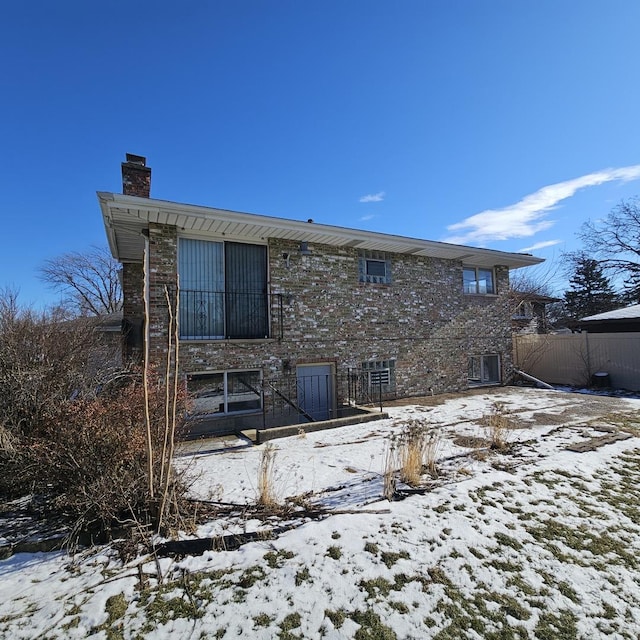 view of snow covered back of property