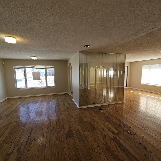 unfurnished room with a textured ceiling and hardwood / wood-style flooring