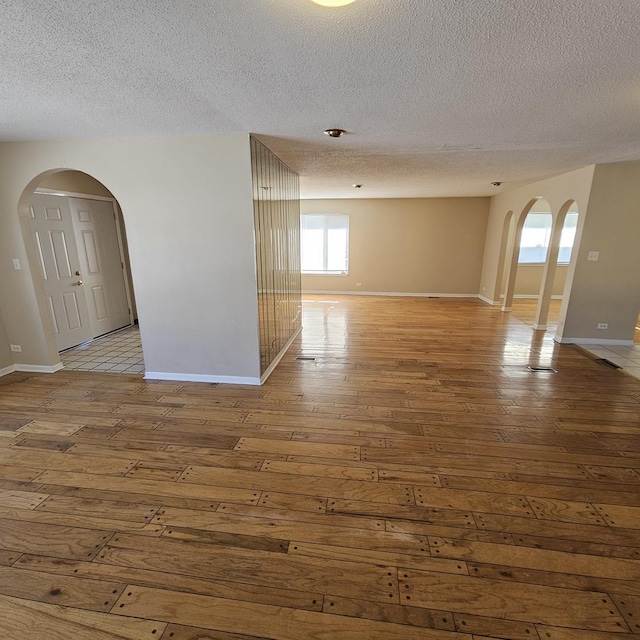 unfurnished room featuring a textured ceiling and light hardwood / wood-style flooring