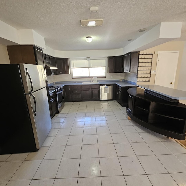 kitchen featuring light tile patterned floors, decorative backsplash, appliances with stainless steel finishes, and sink