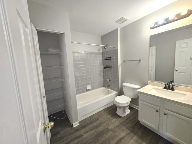 full bathroom with tiled shower / bath, vanity, toilet, and hardwood / wood-style floors