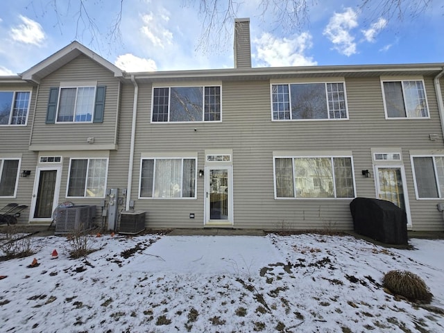 snow covered house with central air condition unit