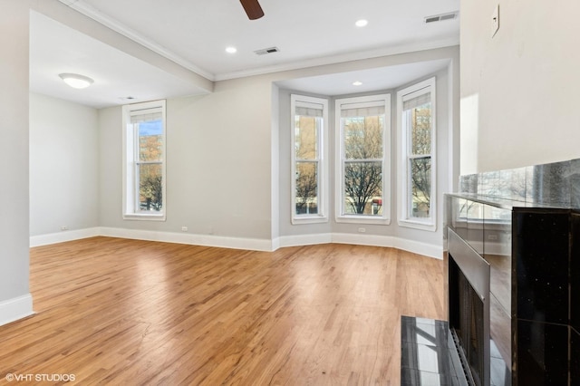 unfurnished living room with ornamental molding, ceiling fan, and light hardwood / wood-style floors