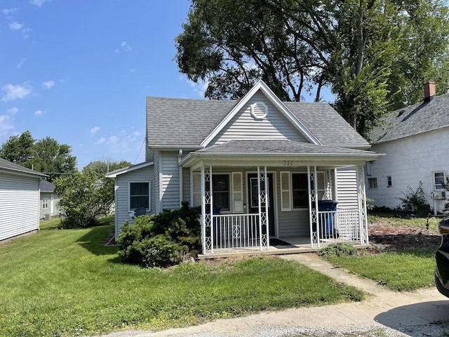 bungalow with covered porch and a front yard