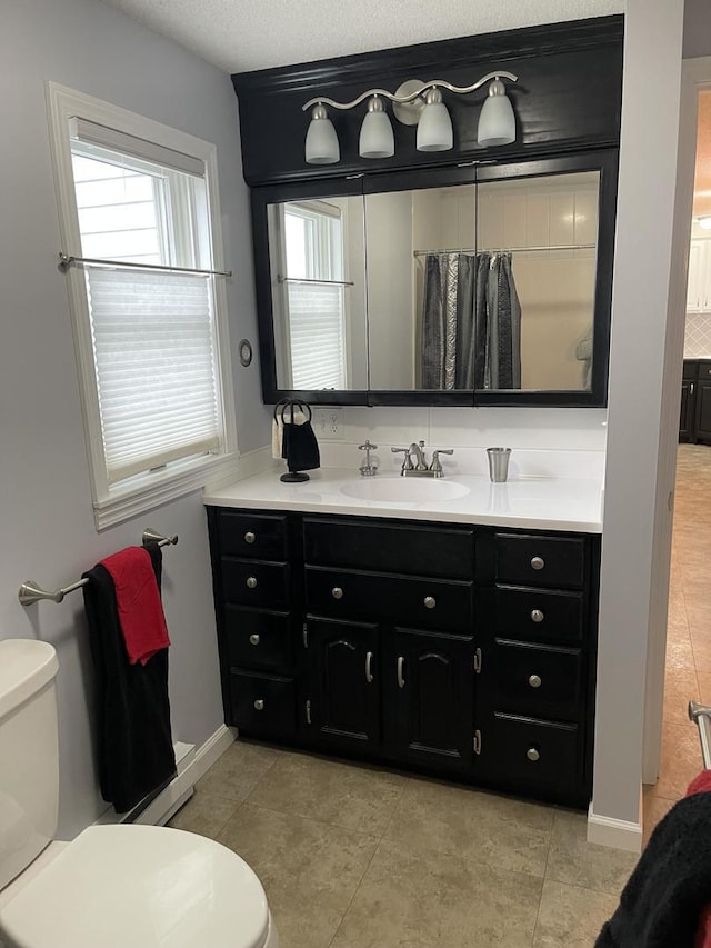 bathroom featuring toilet, tile patterned flooring, and vanity