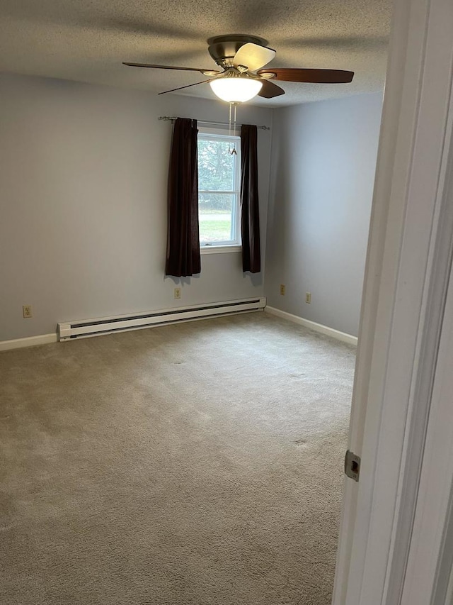 carpeted spare room with ceiling fan, a baseboard radiator, and a textured ceiling