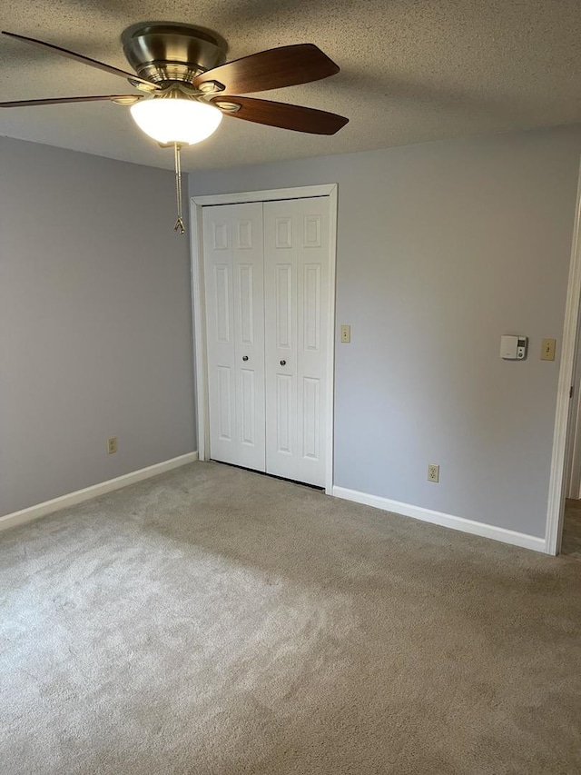 unfurnished bedroom featuring ceiling fan, a closet, carpet, and a textured ceiling