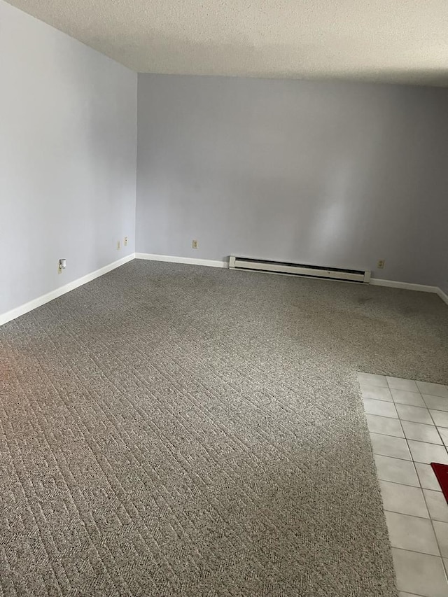 empty room featuring a baseboard heating unit and a textured ceiling