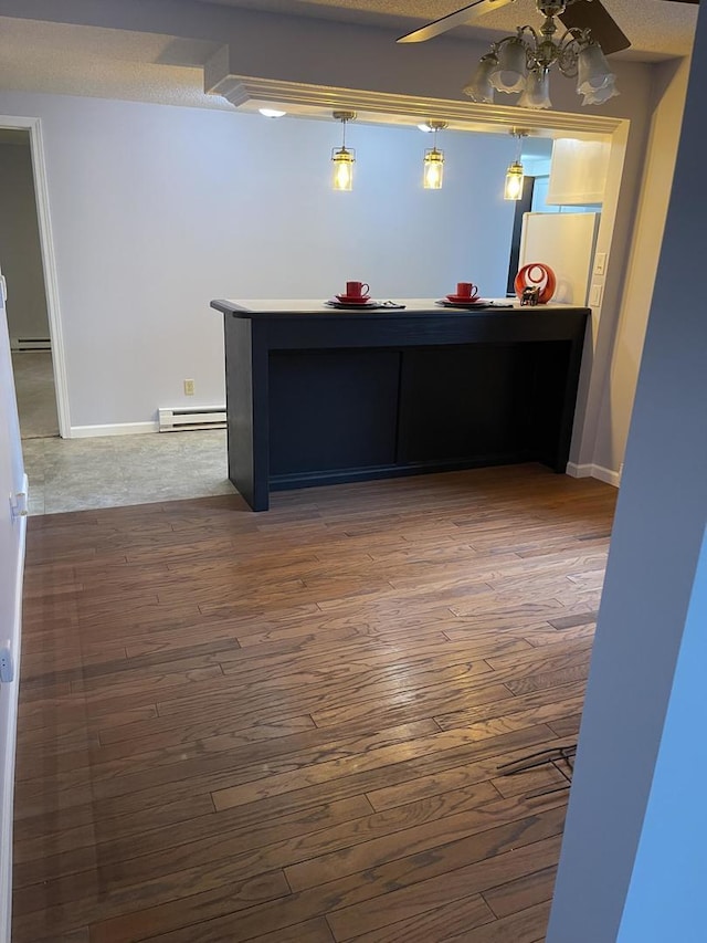 interior space with a baseboard heating unit, ceiling fan, and hardwood / wood-style floors