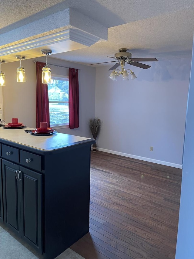 kitchen featuring ceiling fan, dark hardwood / wood-style floors, a textured ceiling, and pendant lighting