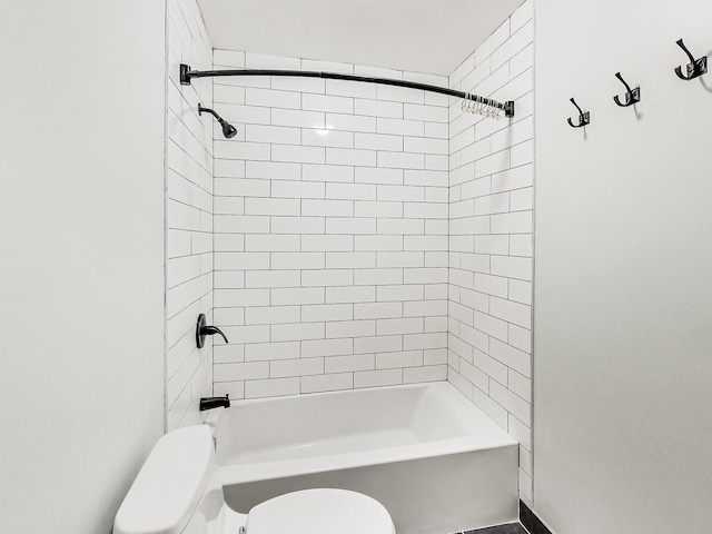 bathroom featuring tiled shower / bath combo and toilet