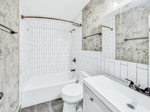 full bathroom featuring tile walls, vanity, tile patterned floors, toilet, and tiled shower / bath