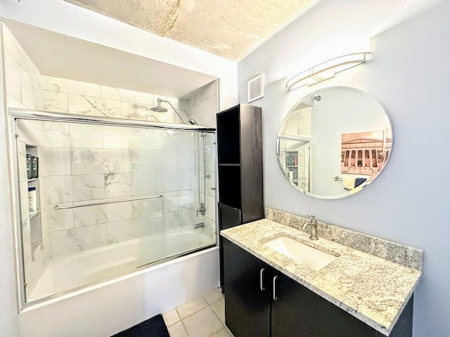 bathroom featuring bath / shower combo with glass door, tile patterned floors, and vanity