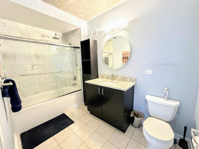 full bathroom with tile patterned floors, toilet, tiled shower / bath, and vanity