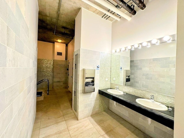 bathroom featuring sink and tile walls