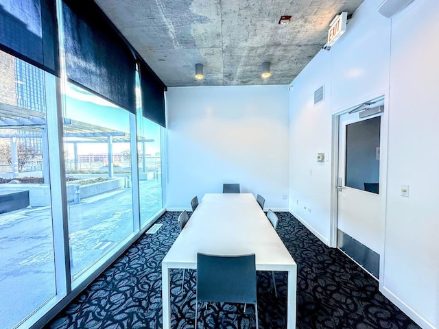 carpeted office featuring a wall of windows