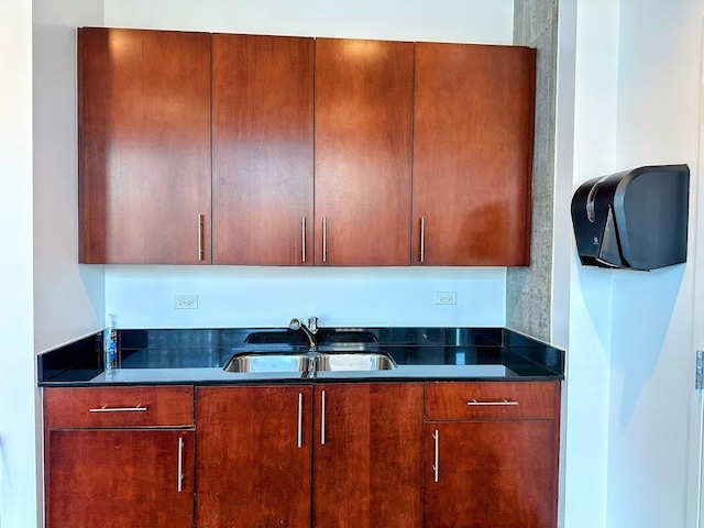 kitchen featuring sink and dark stone countertops