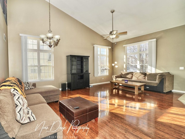 living room with high vaulted ceiling, dark wood-type flooring, and ceiling fan with notable chandelier