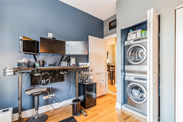 laundry room with stacked washing maching and dryer and light wood-type flooring