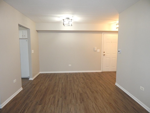 empty room with dark hardwood / wood-style flooring