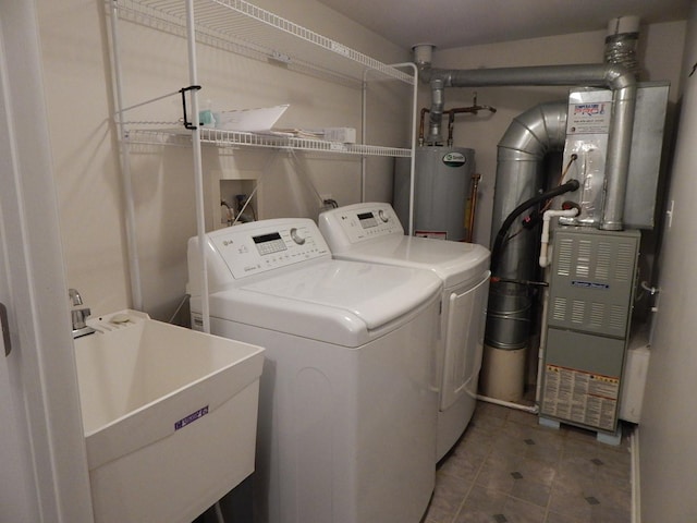 washroom featuring water heater, heating unit, washing machine and clothes dryer, and sink