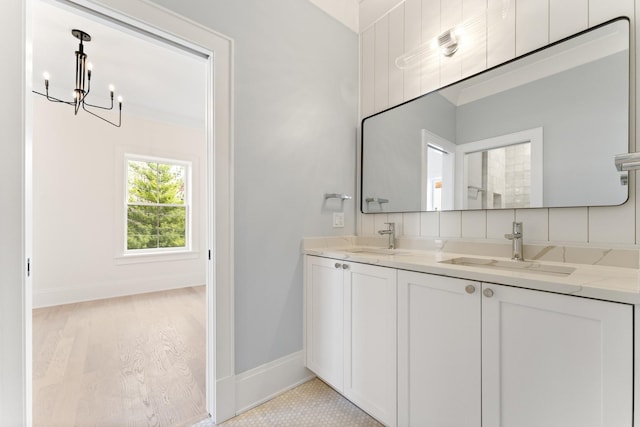 1254 W Norwood St, Chicago, IL 60660 - bathroom featuring baseboards, a sink, a notable chandelier, and double vanity