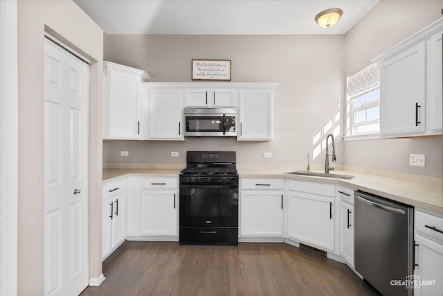 kitchen with stainless steel appliances, dark hardwood / wood-style flooring, sink, and white cabinets