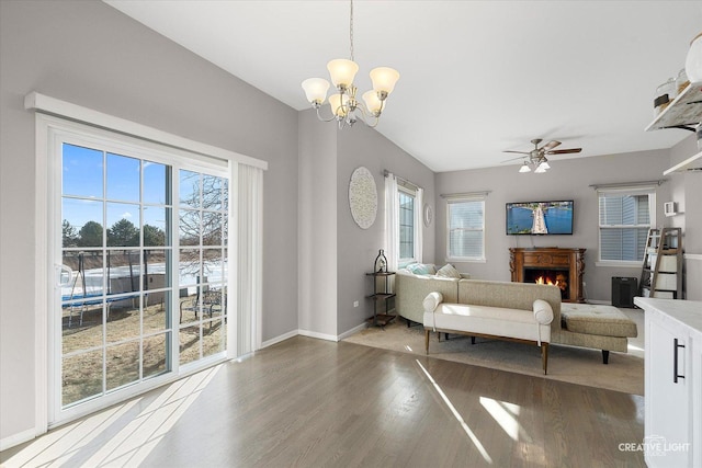 living room with hardwood / wood-style flooring and ceiling fan with notable chandelier