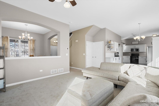 living room with ceiling fan with notable chandelier and light colored carpet