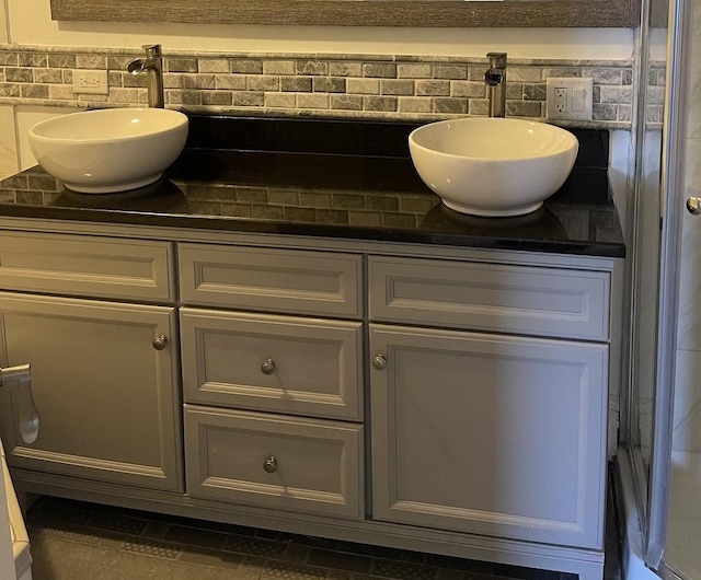 bathroom featuring backsplash, tile patterned flooring, and vanity