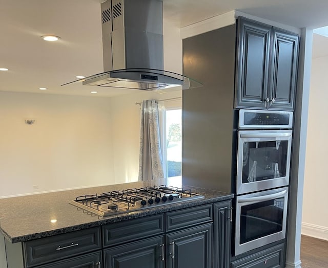 kitchen with dark hardwood / wood-style floors, dark stone countertops, island exhaust hood, and stainless steel appliances