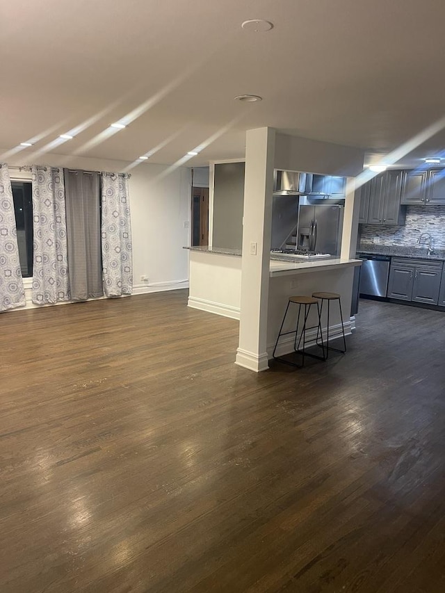 unfurnished living room with sink and dark hardwood / wood-style flooring