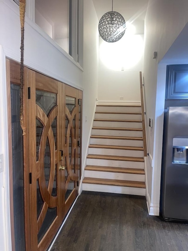 stairway with a towering ceiling and hardwood / wood-style floors