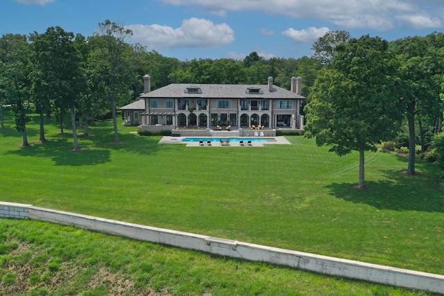 rear view of property with a balcony and a yard