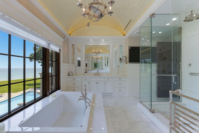 bathroom with lofted ceiling, a water view, shower with separate bathtub, a chandelier, and vanity