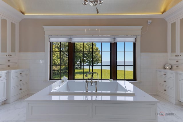 bathroom featuring vanity, a water view, tile walls, and a tub to relax in