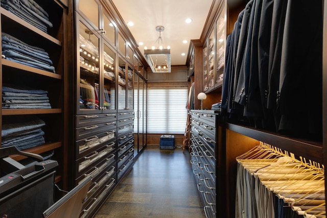 spacious closet featuring dark wood-type flooring and a chandelier